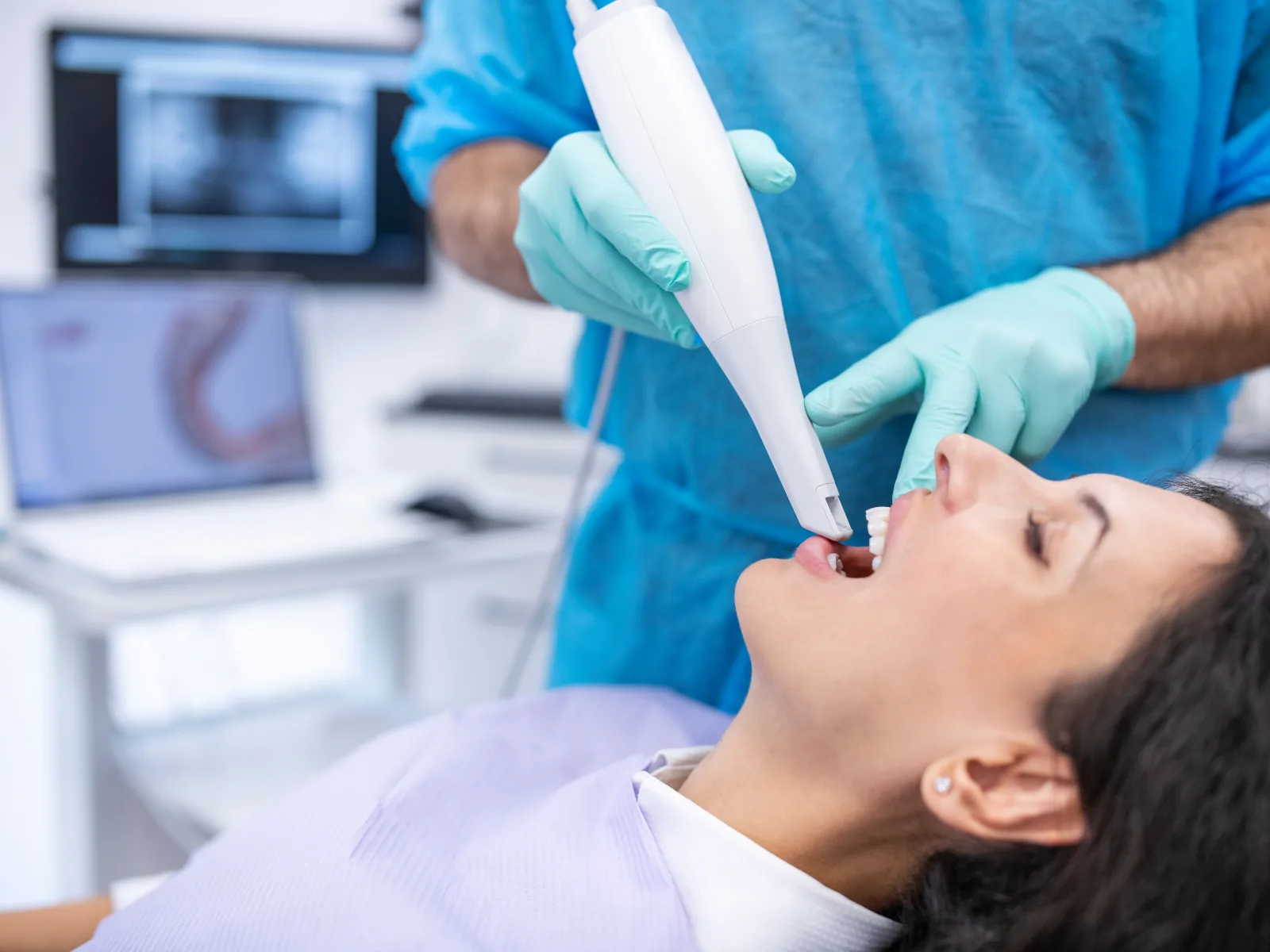 Escáner intraoral 3D tomando el registro de mordida de una paciente en la clínica
